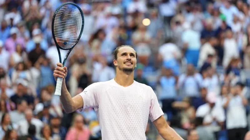 Tennis player celebrating with racket raised in crowd