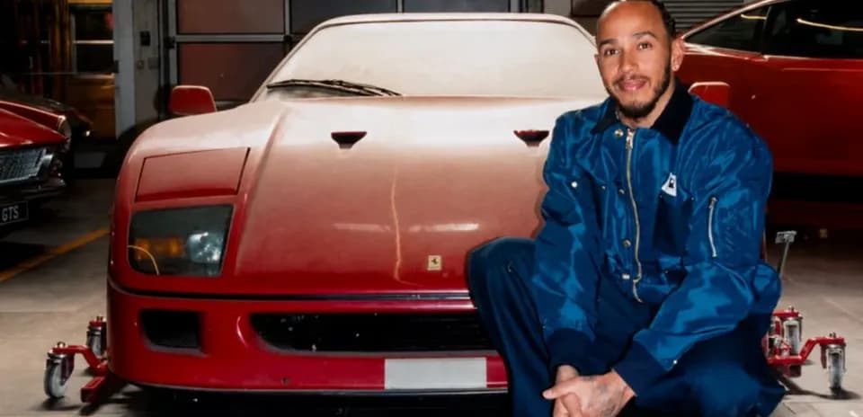 Man kneeling beside a red Ferrari in garage