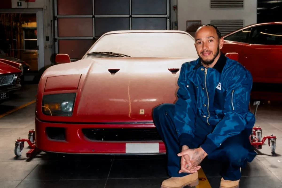 Man kneeling beside a red Ferrari in garage