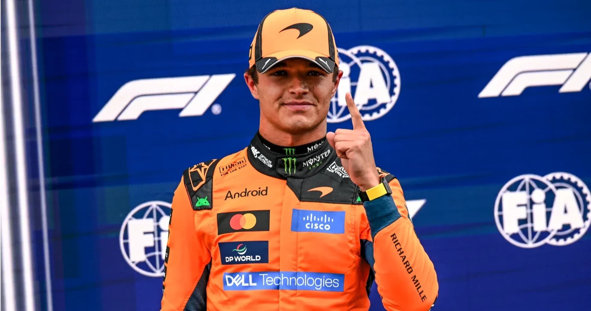 Driver celebrating with finger raised on podium