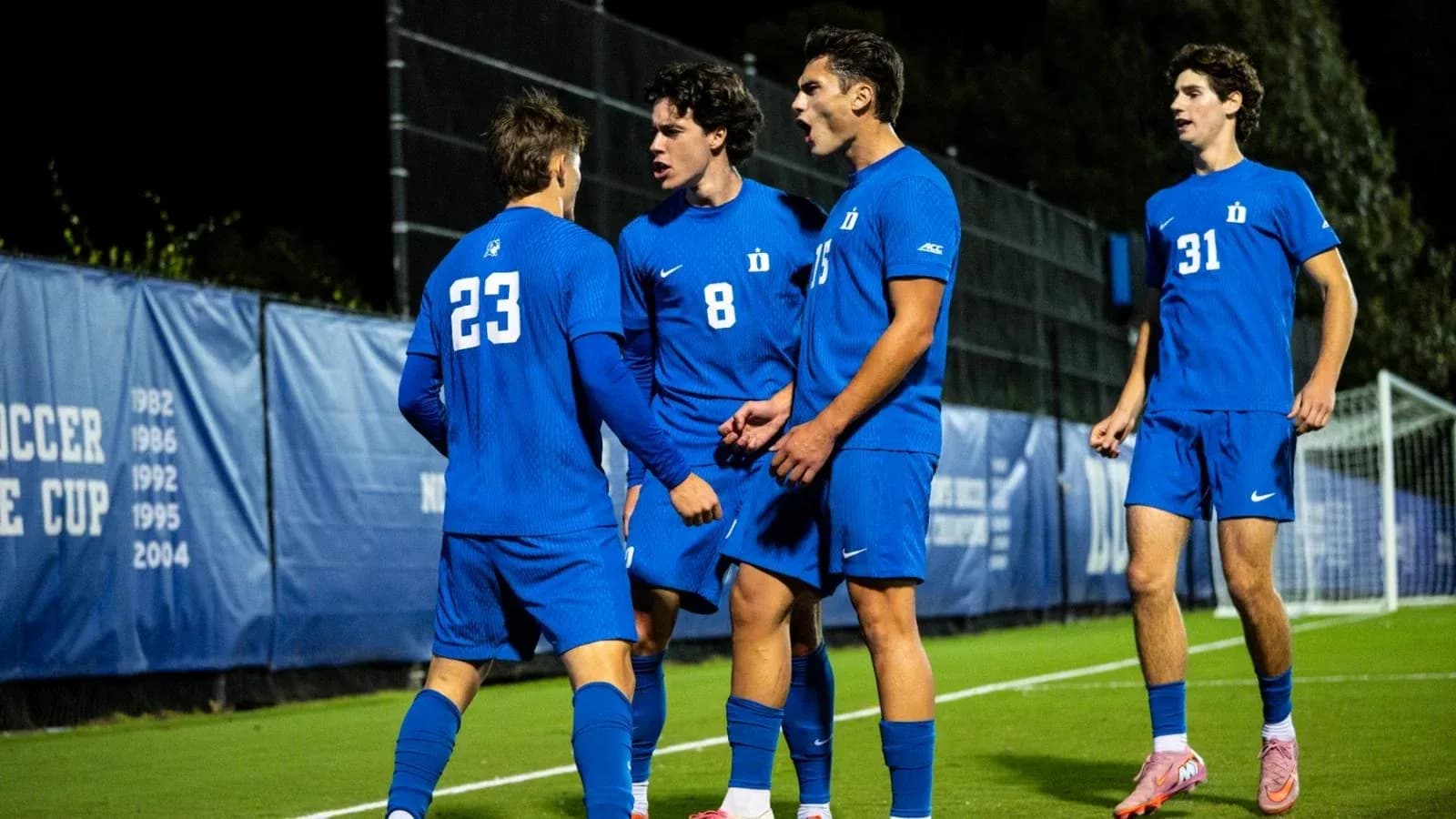 Duke players celebrating a goal on the field