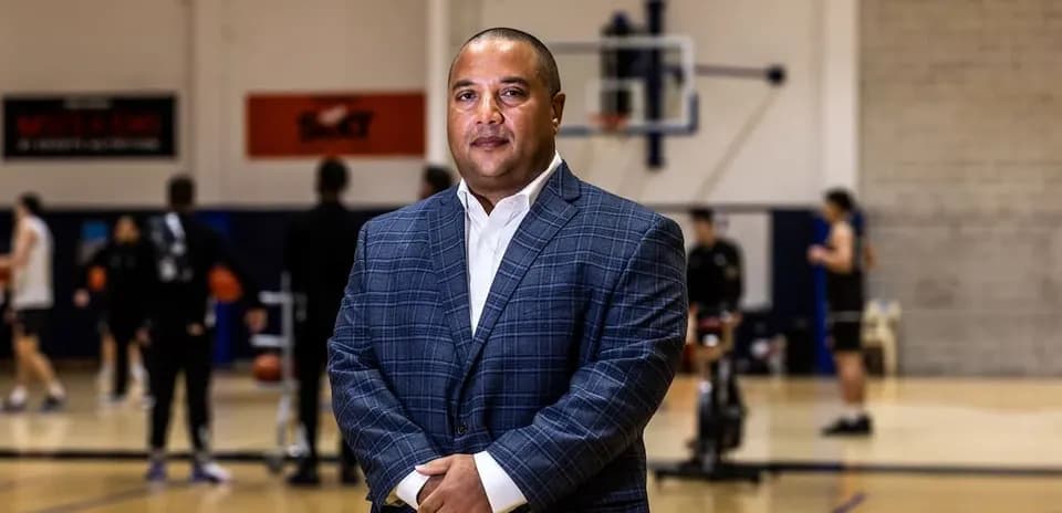 Man in suit standing in basketball training facility