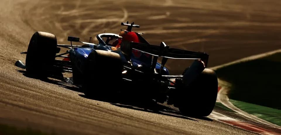 Formula 1 car racing on track during sunset