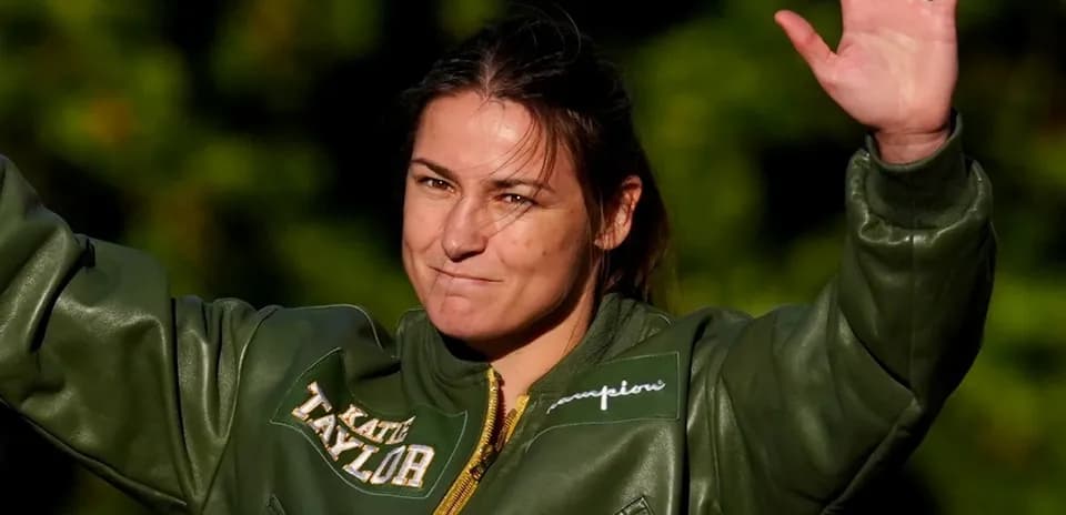 Athlete waving while wearing a green jacket