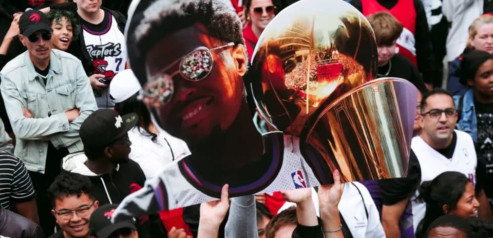 Fans celebrating with a large trophy and poster