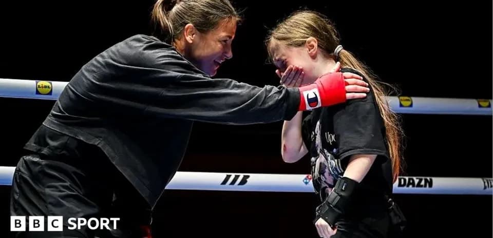 Boxer encouraging young girl in training ring