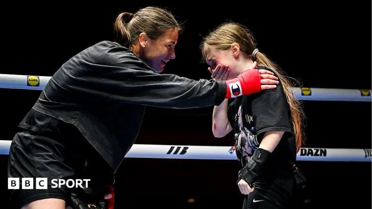 Boxer encouraging young girl in training ring