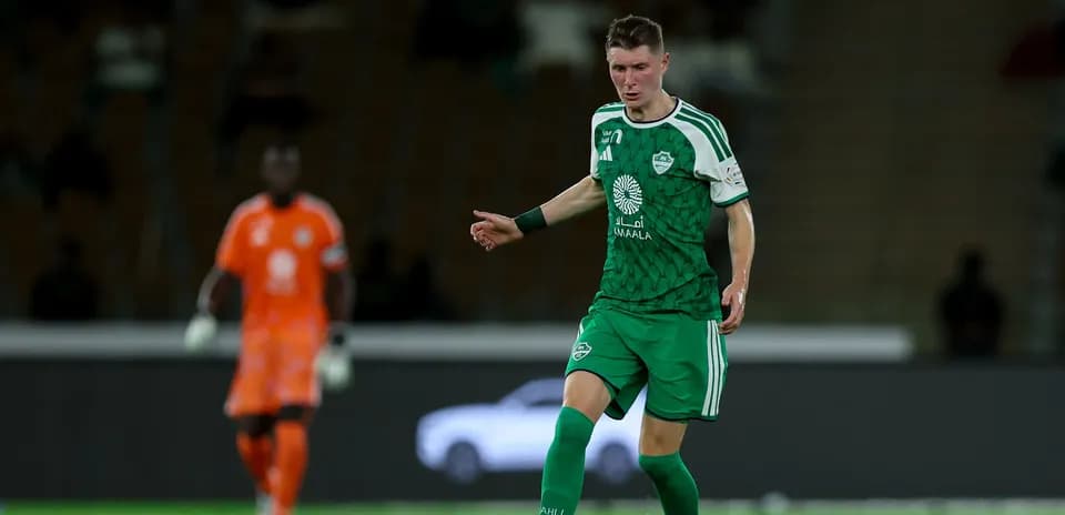 Player in green kit dribbling the ball during match