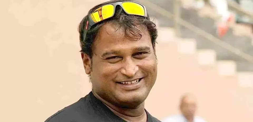 Man smiling wearing sunglasses at sports venue