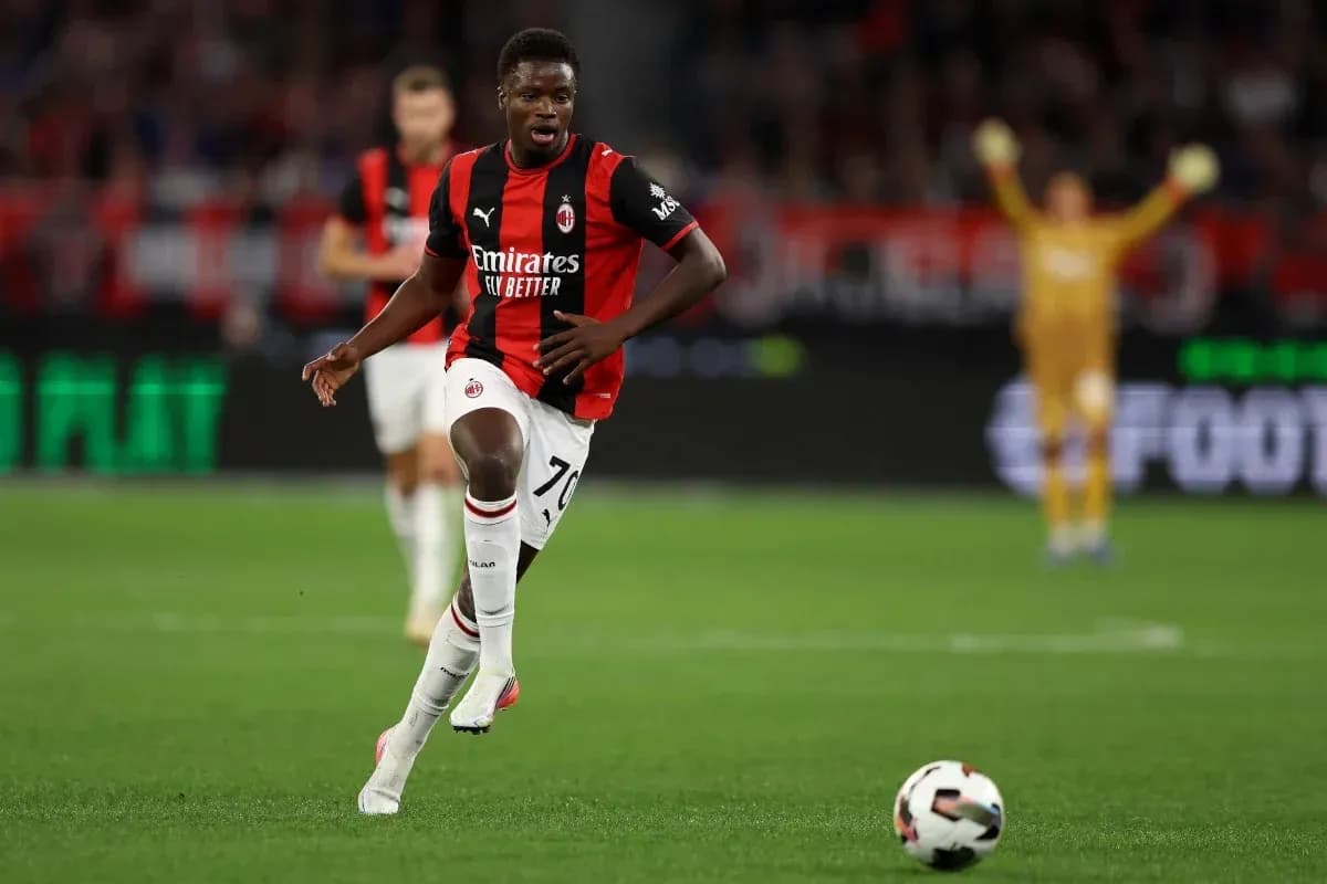 Player in AC Milan kit running with ball