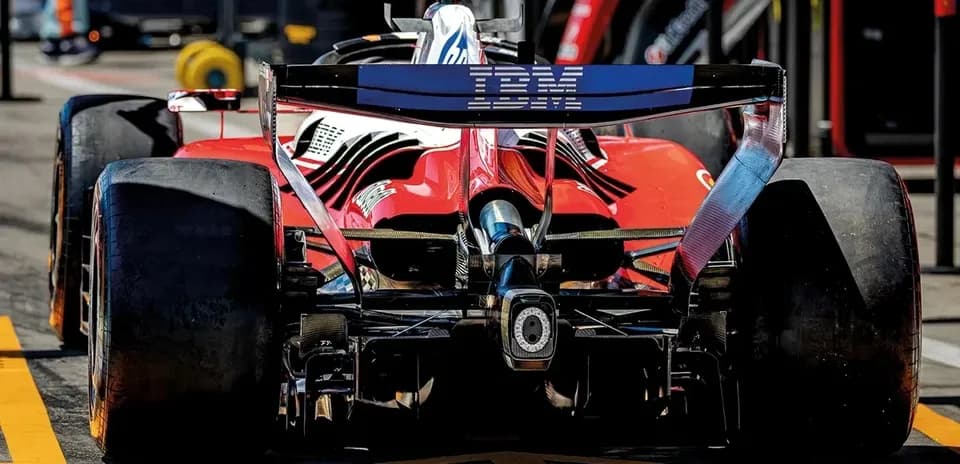 Rear view of red Formula 1 car in pit lane