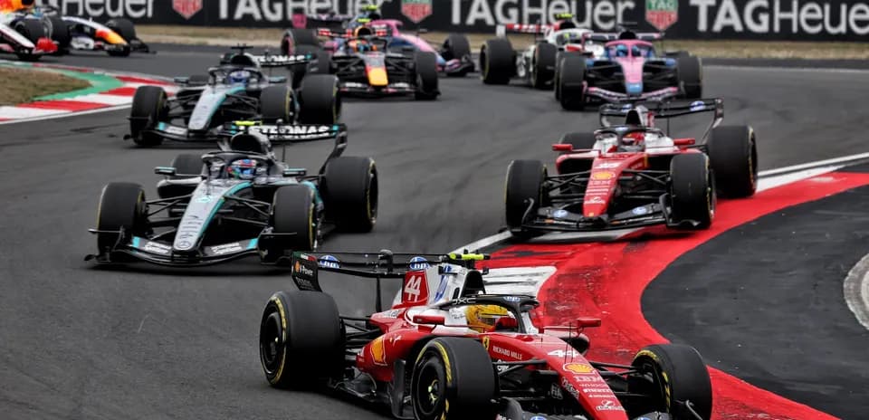 Multiple Formula 1 cars racing on track corner
