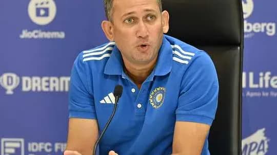 Coach speaking at a press conference table