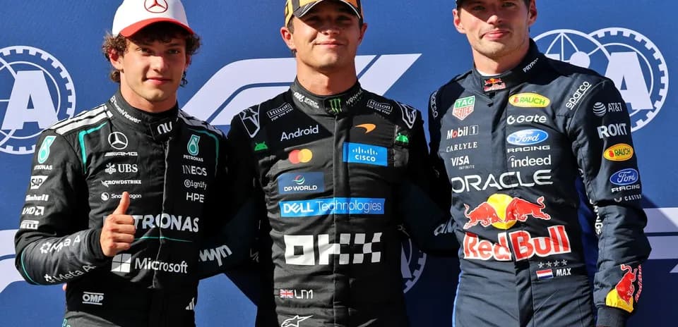 Three Formula 1 drivers posing on podium