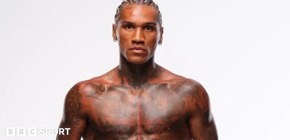 Tattooed athlete posing against a white background