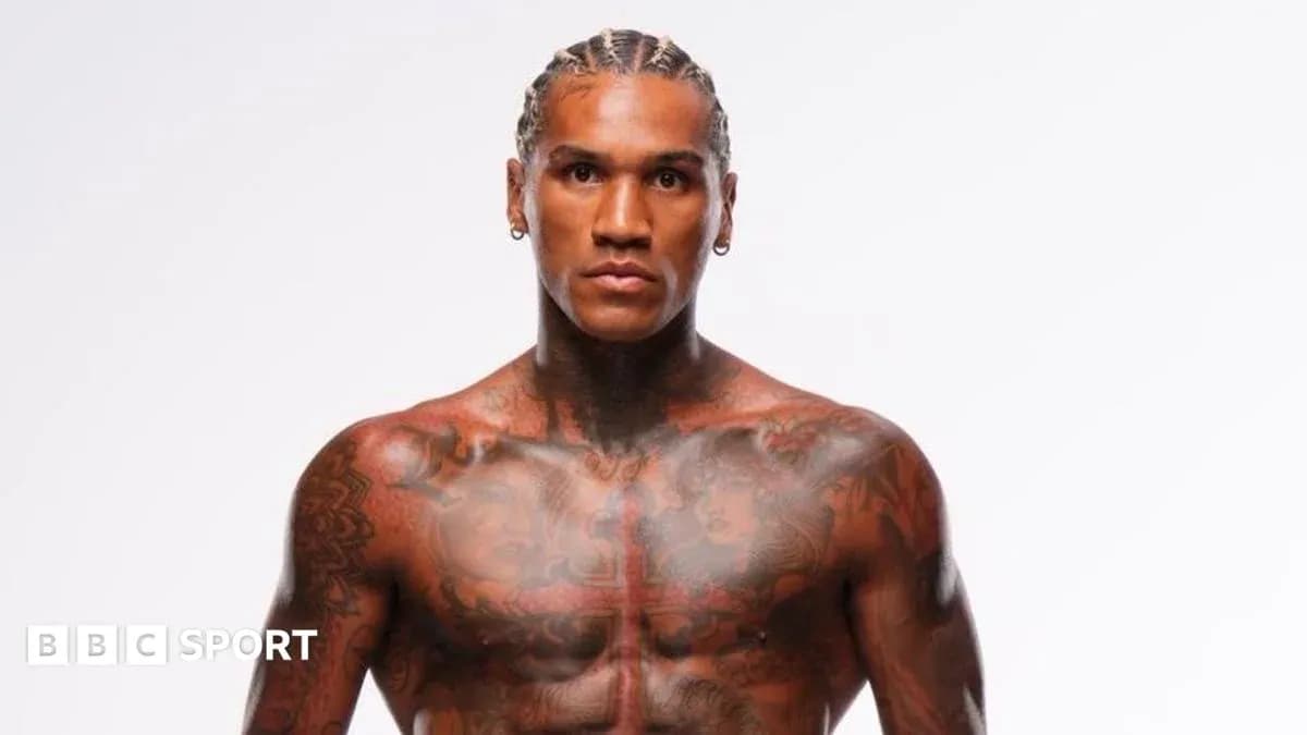 Tattooed athlete posing against a white background