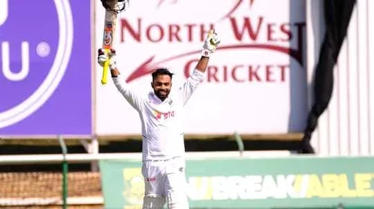 Batsman celebrating century with raised bat