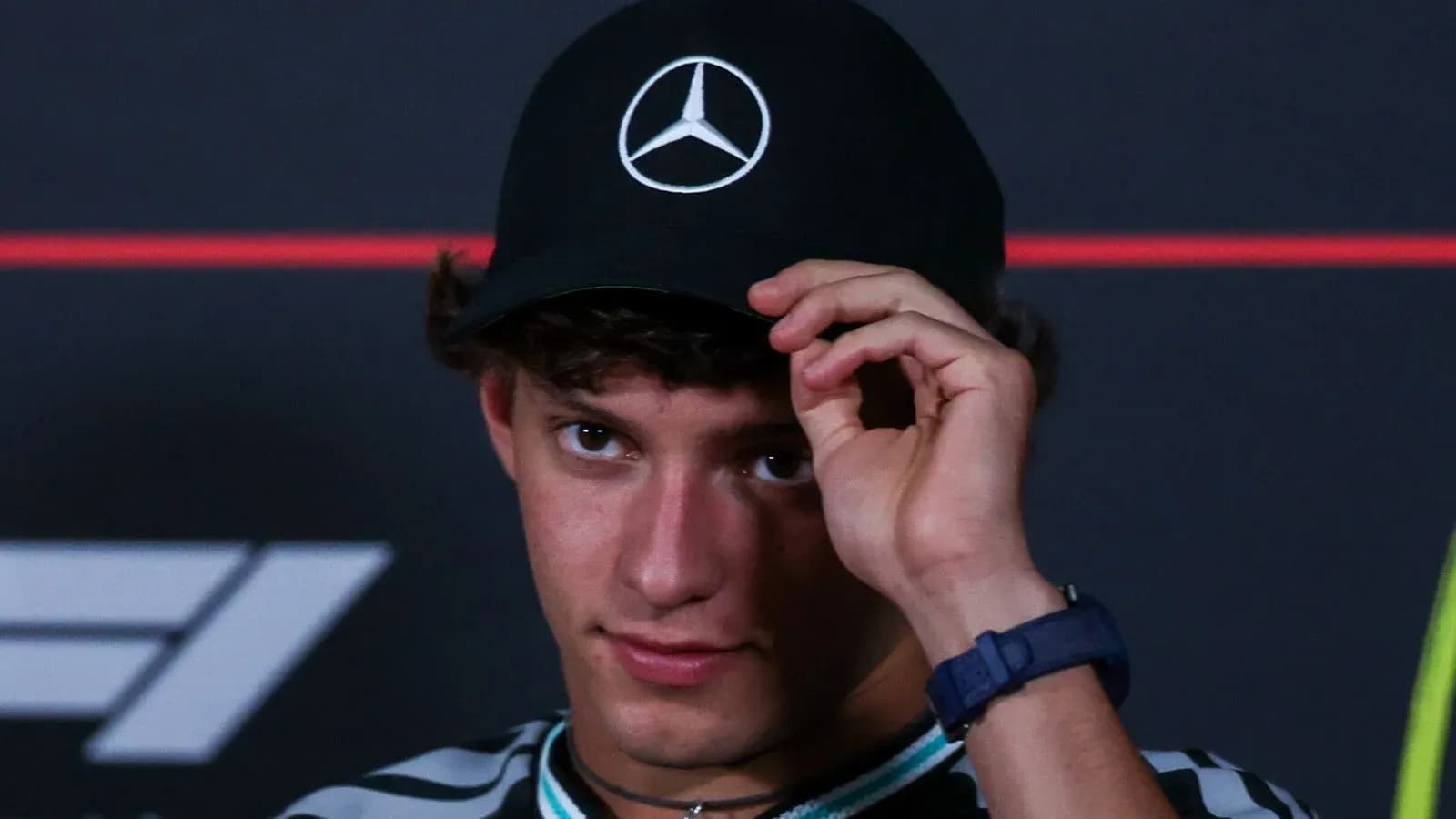 Young man adjusting cap during press event