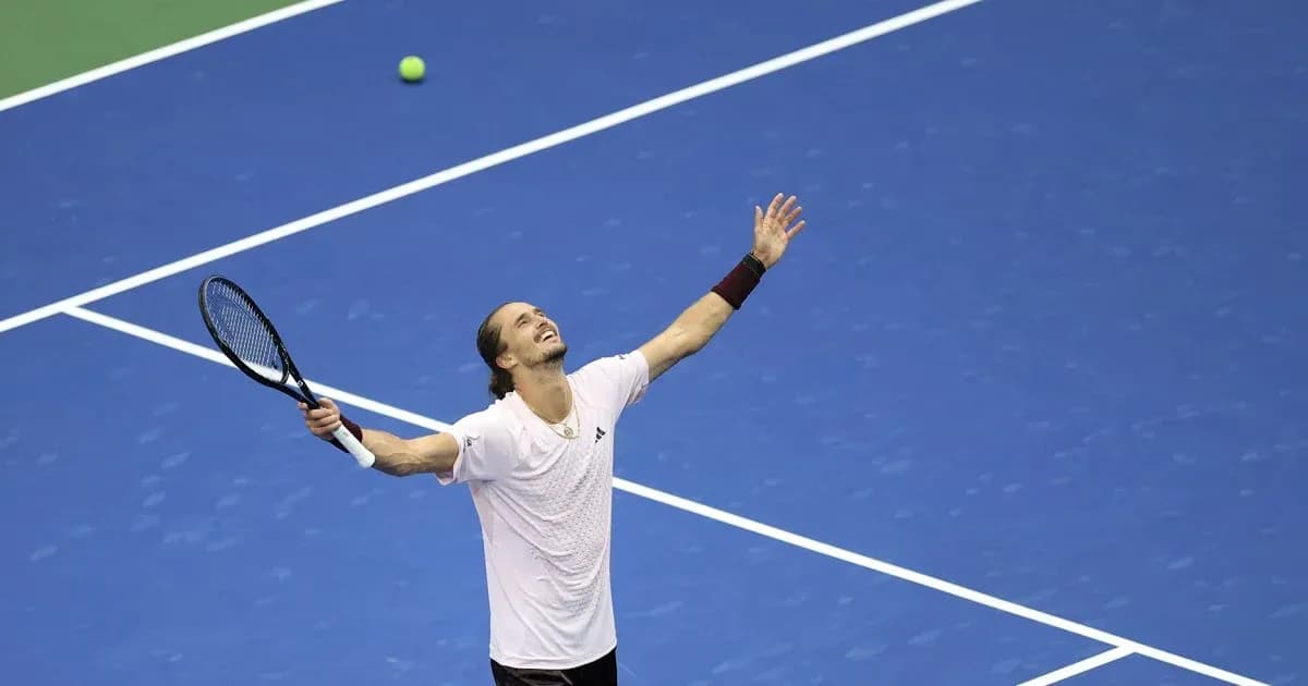 Tennis player celebrating on blue court with racket