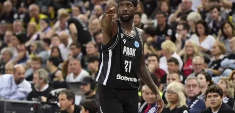 Player gesturing during basketball game with crowd behind