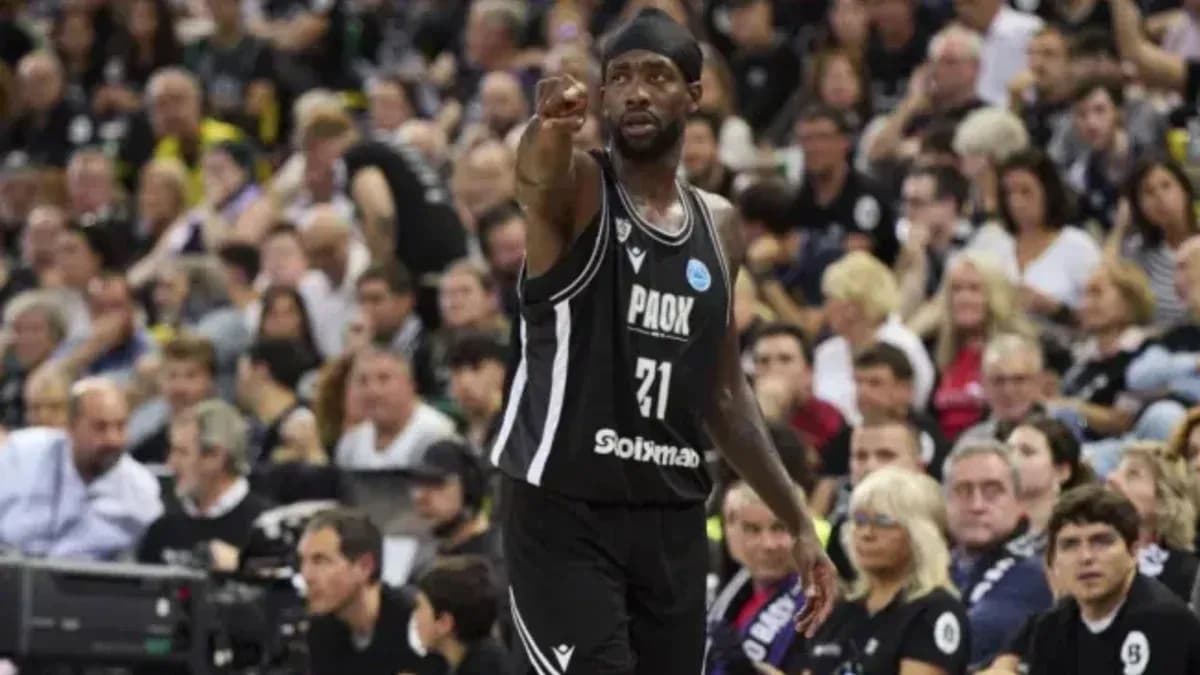 Player gesturing during basketball game with crowd behind