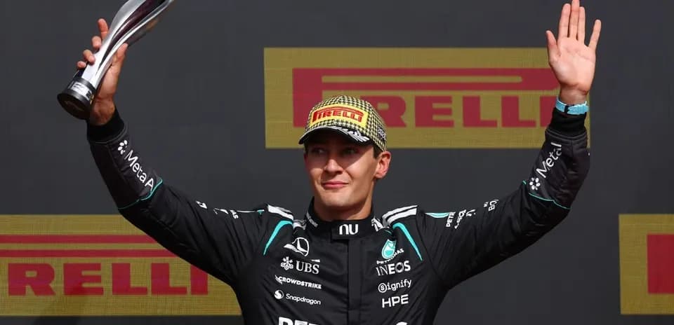 Driver celebrating with trophy on podium
