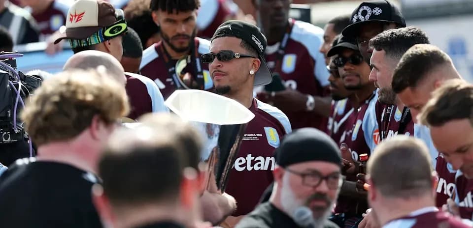 Aston Villa players celebrating with trophy in crowd