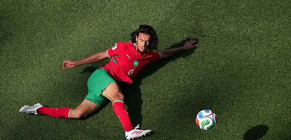 Player in red and green uniform sliding for the ball