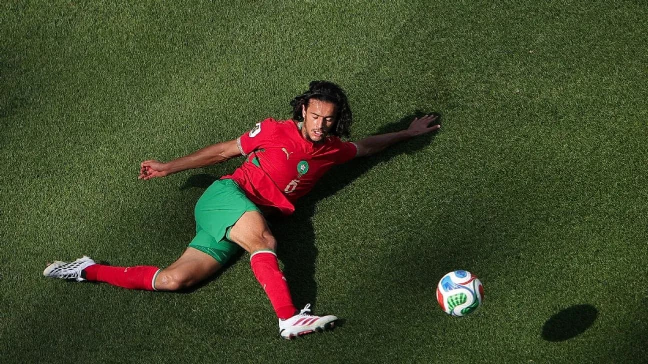 Player in red and green uniform sliding for the ball