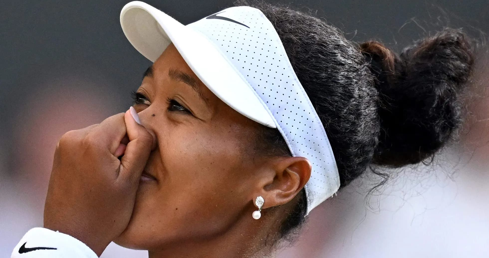 Tennis player celebrating with hand on face