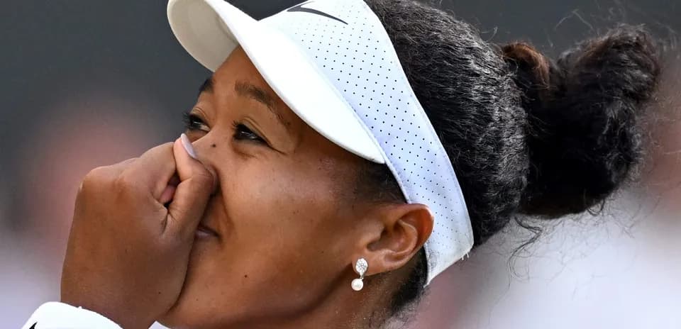 Tennis player celebrating with hand on face