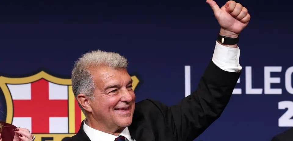 Man raising hand at election event with Barcelona logo