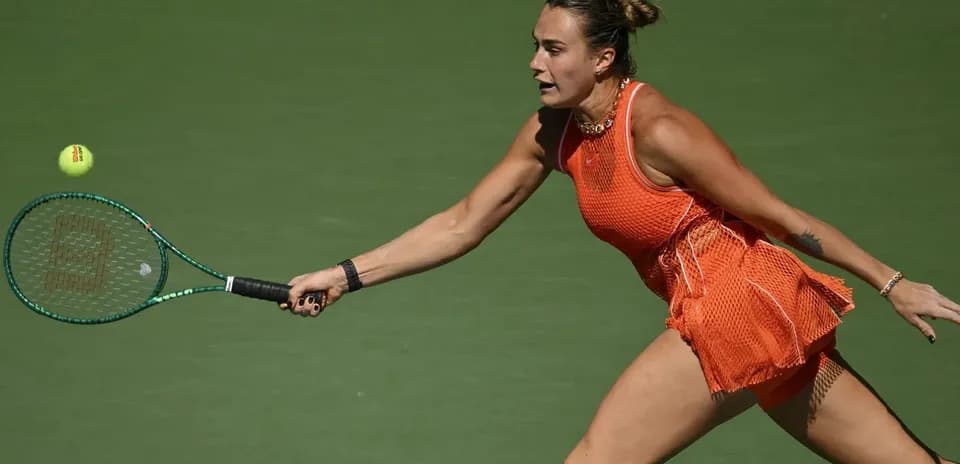 Player reaching for a tennis ball with racket
