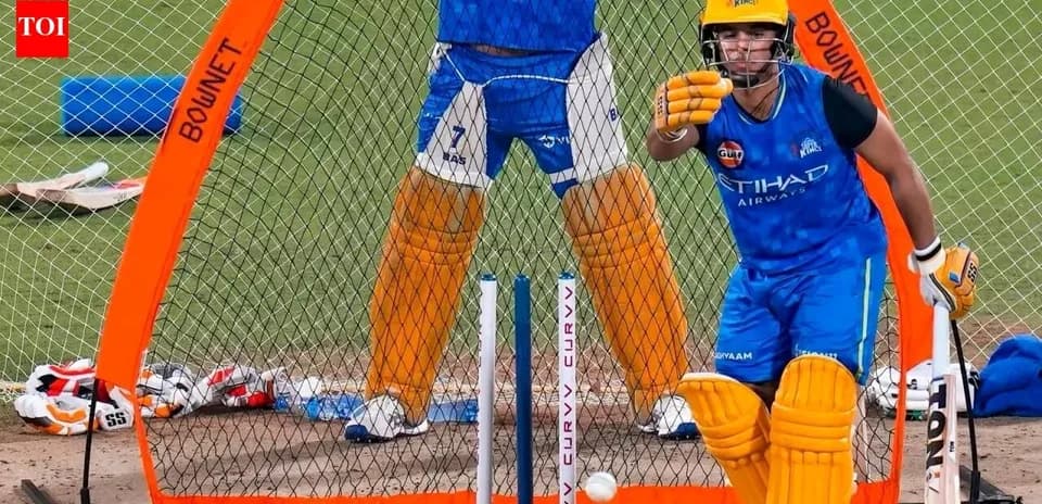 Batsman practicing in nets with bowler behind