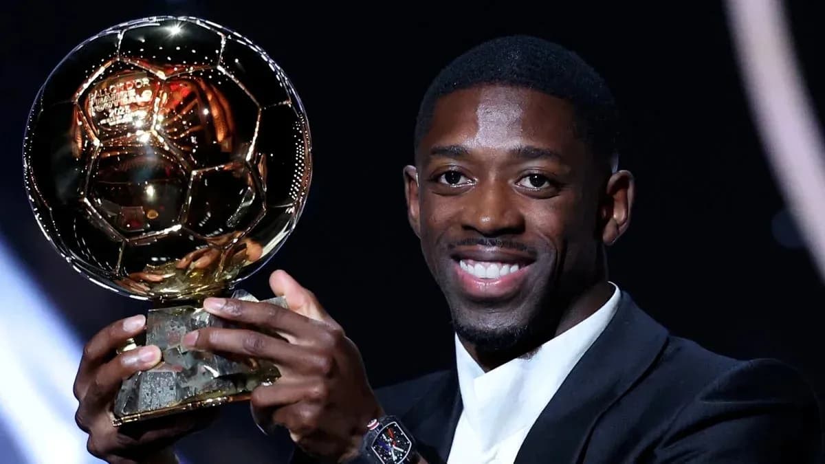 Player holding Ballon d'Or trophy on stage