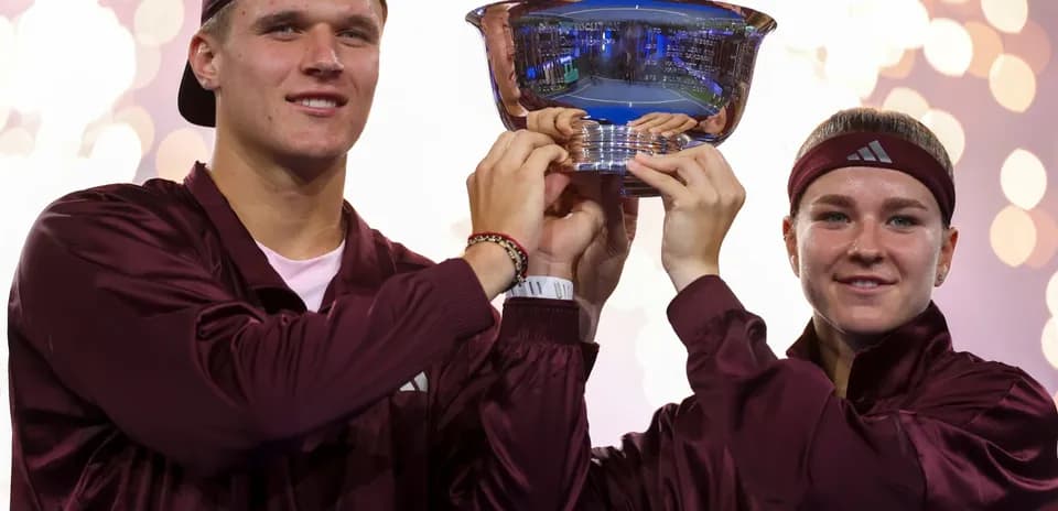 Players celebrating victory with trophy at event