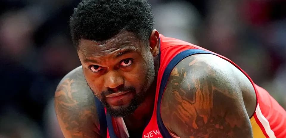Basketball player in red jersey looking intently