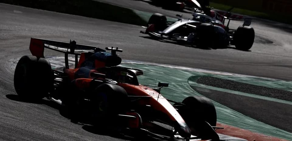 Formula 1 cars racing on a circuit corner