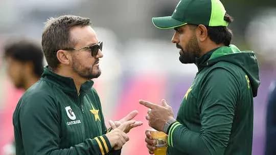 Two cricket team members discussing strategies outdoors