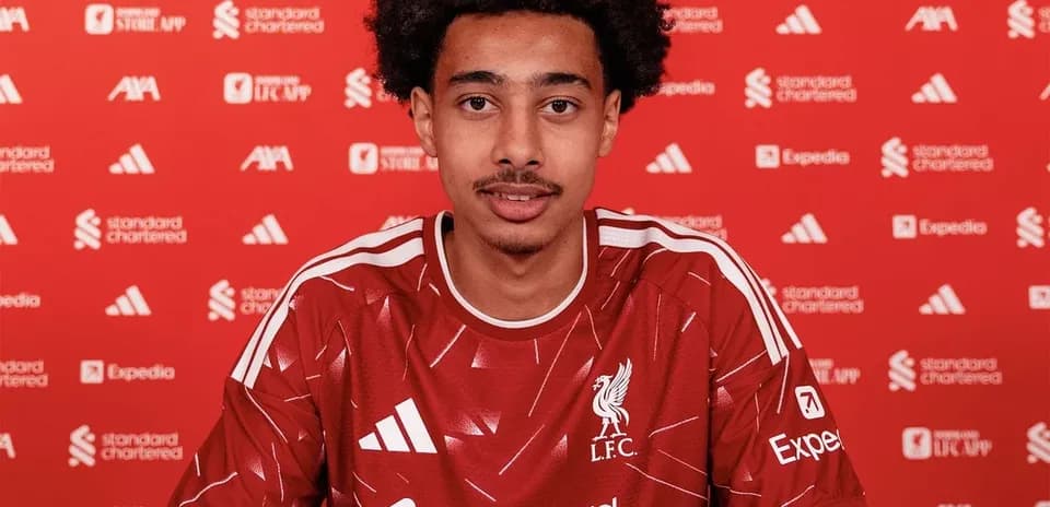 Player signing contract in Liverpool jersey at event
