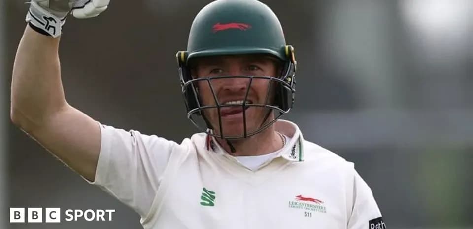 Cricketer celebrating with raised arm during match