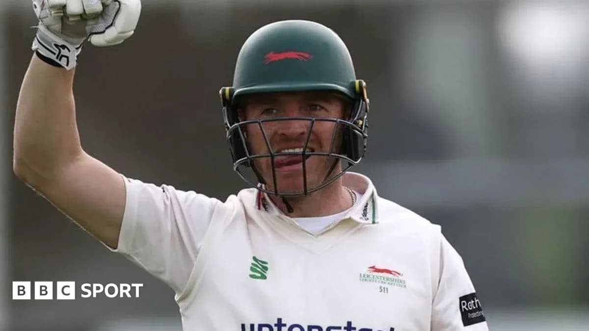 Cricketer celebrating with raised arm during match