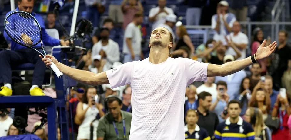 Player celebrating victory with arms raised in stadium