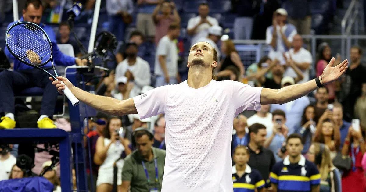 Player celebrating victory with arms raised in stadium
