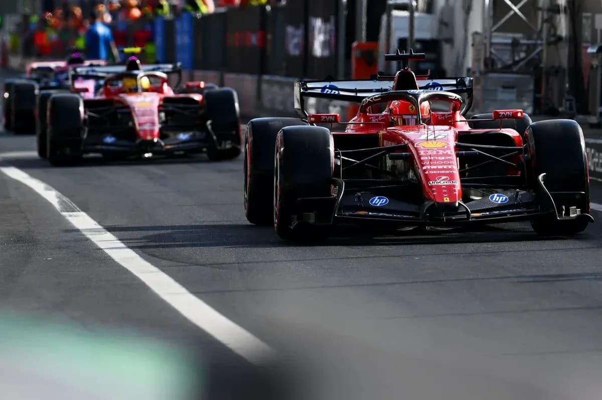 Two Ferrari cars driving on the pit lane Two Ferrari cars driving on the pit lane
