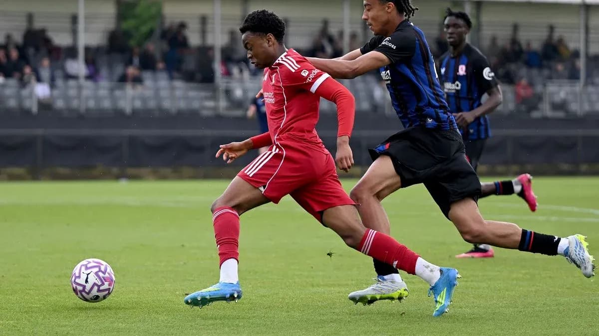 Player in red sprinting while being challenged by opponent Player in red sprinting while being challenged by opponent