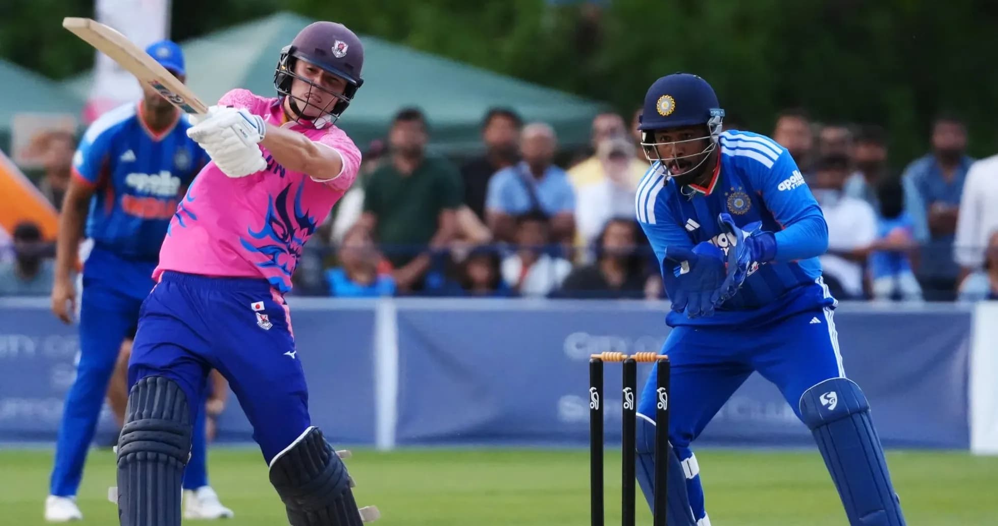 Batsman playing a shot while wicketkeeper prepares Batsman playing a shot while wicketkeeper prepares