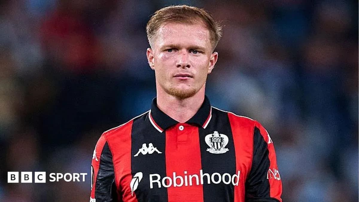 Player in red and black jersey on field Player in red and black jersey on field
