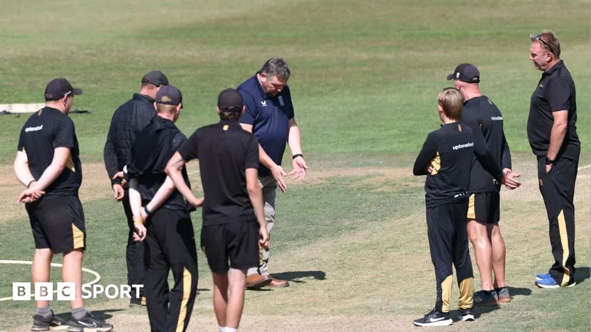 Coaches discussing strategy on cricket field Coaches discussing strategy on cricket field