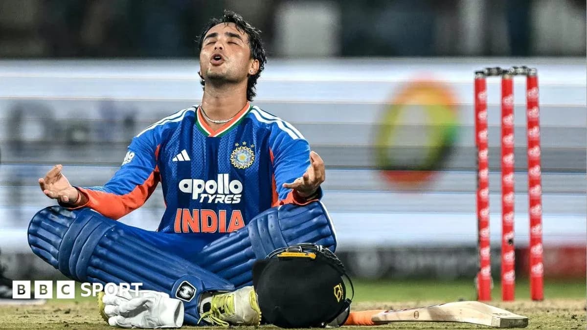 Cricketer in India jersey sitting on pitch Cricketer in India jersey sitting on pitch